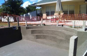 backyard swimming pool under construction - shaped entry steps