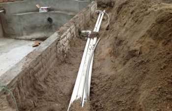 backyard swimming pool under construction- pipe system installation